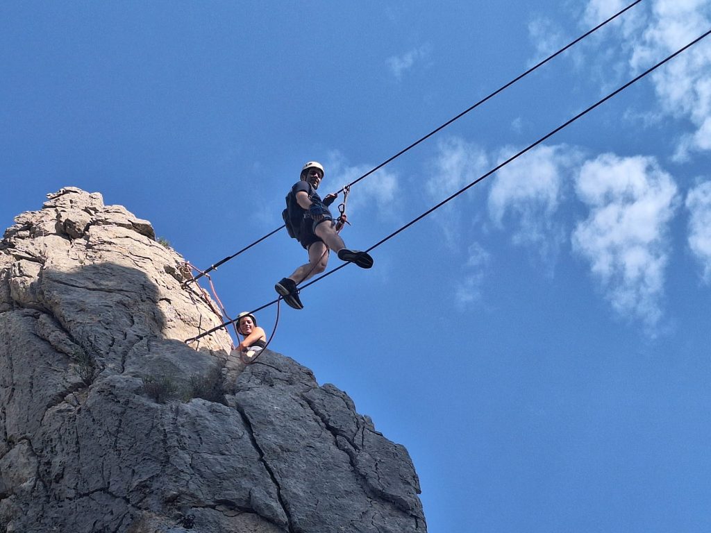 Homme sur un pont de singe de la Via Ferrata du Saint Julien dans la Drôme Provençale